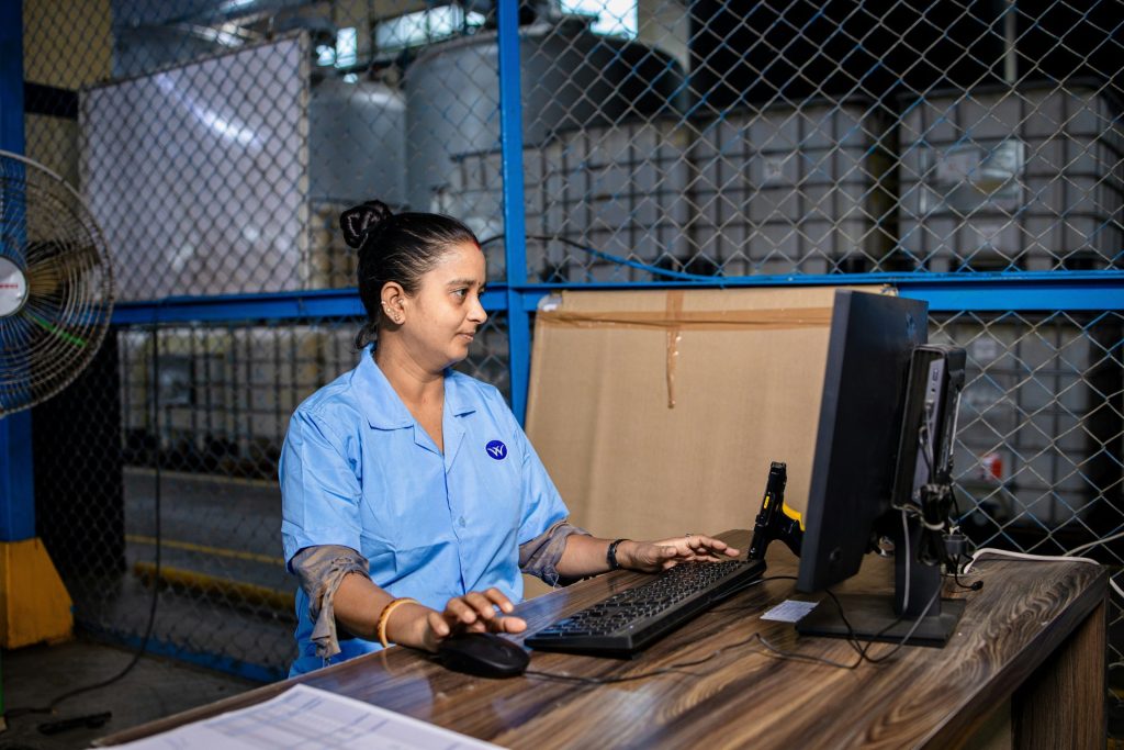 Woman works on a computer in a warehouse.